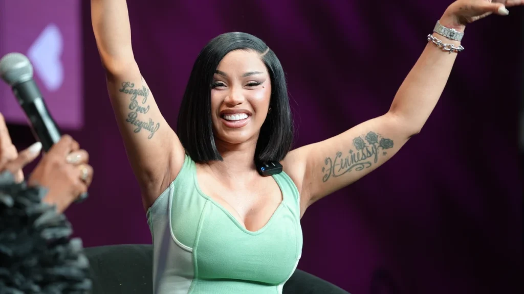 Cardi B performing with both arms raised at the 2026 Essence Festival of Culture