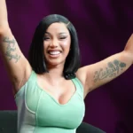 Cardi B performing with both arms raised at the 2026 Essence Festival of Culture