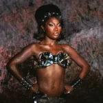 Doechii in a metallic fembot costume from the Bombs Swamp Sessions visual